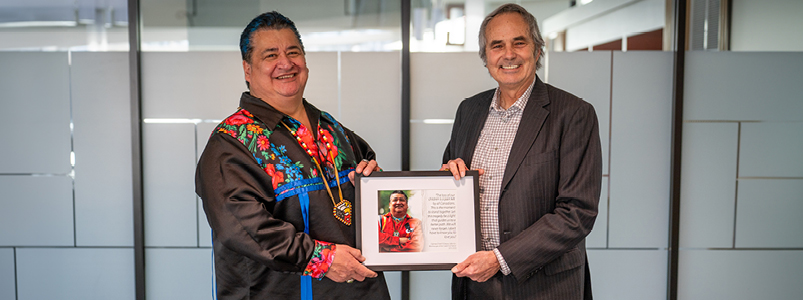 Regional Chair Gary Carr presenting Ogimaa (Chief) Stacey Laforme with a framed picture.